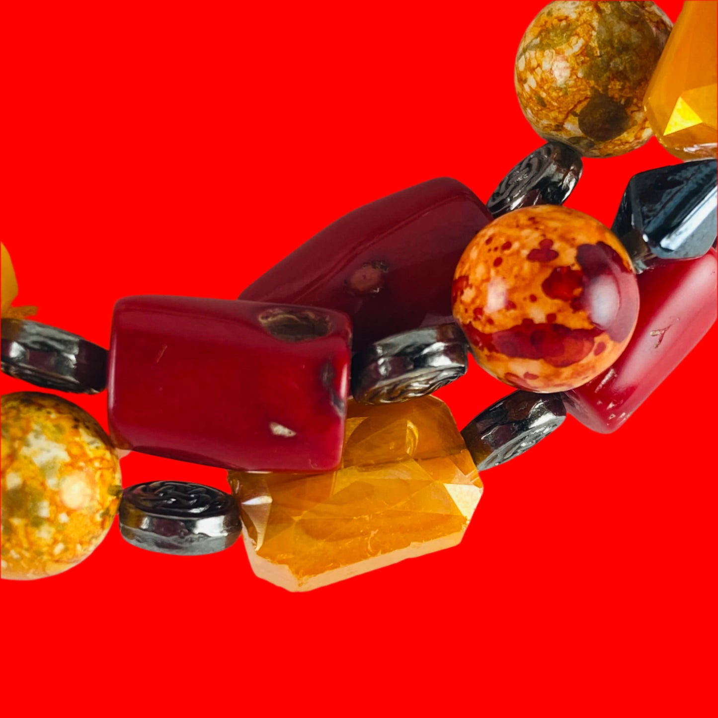 Bracelet with orange, red glass beads accented with gunmetal colored metal beads.  Strung on memory wire.