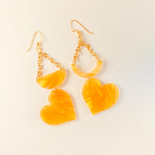 Assymetrical dangling earrings with 3 components: 2 inches of chain, a half moon bead or a crescent moon bead and a heart shaped bead.